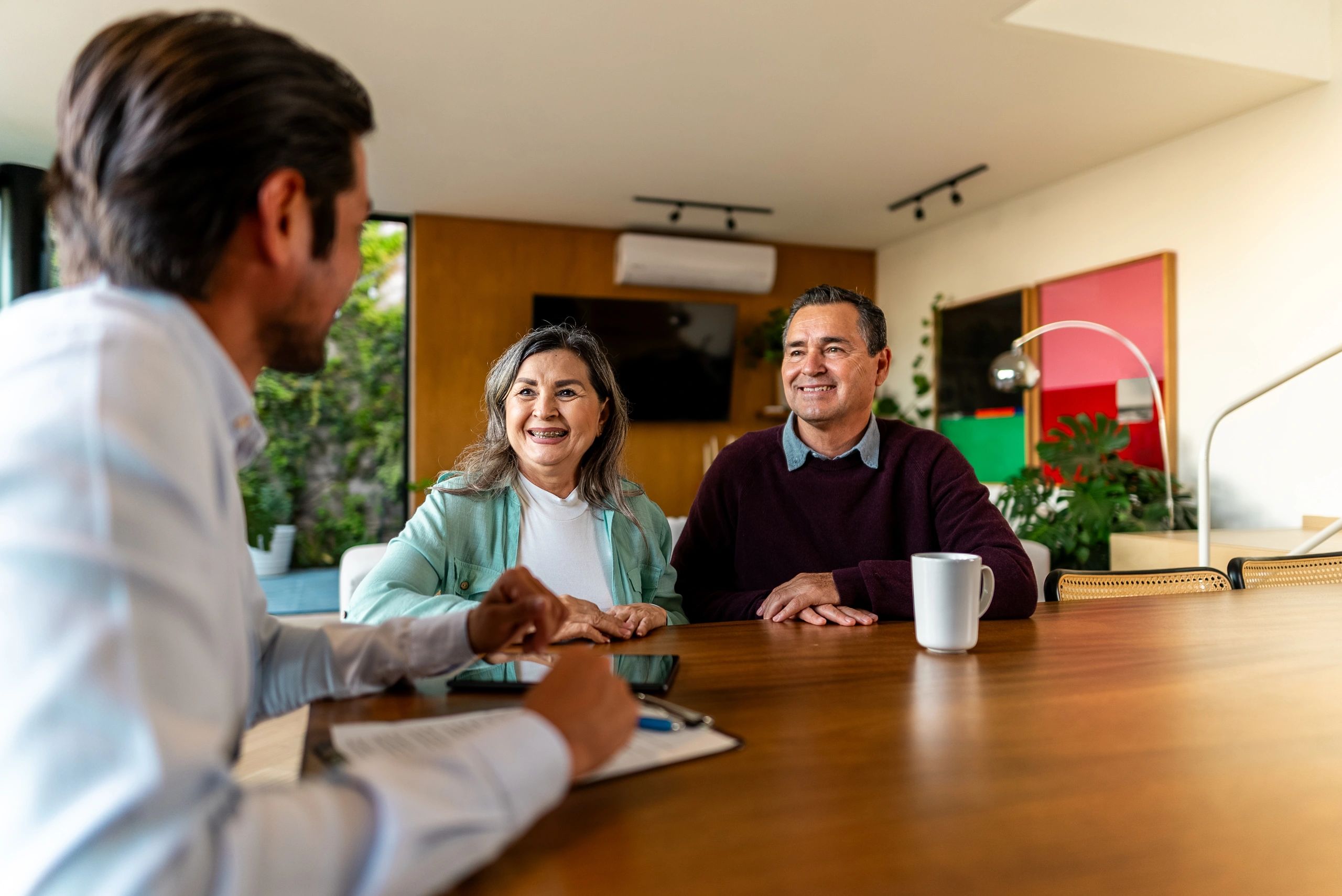 Senior couple talking to real estate agent at house